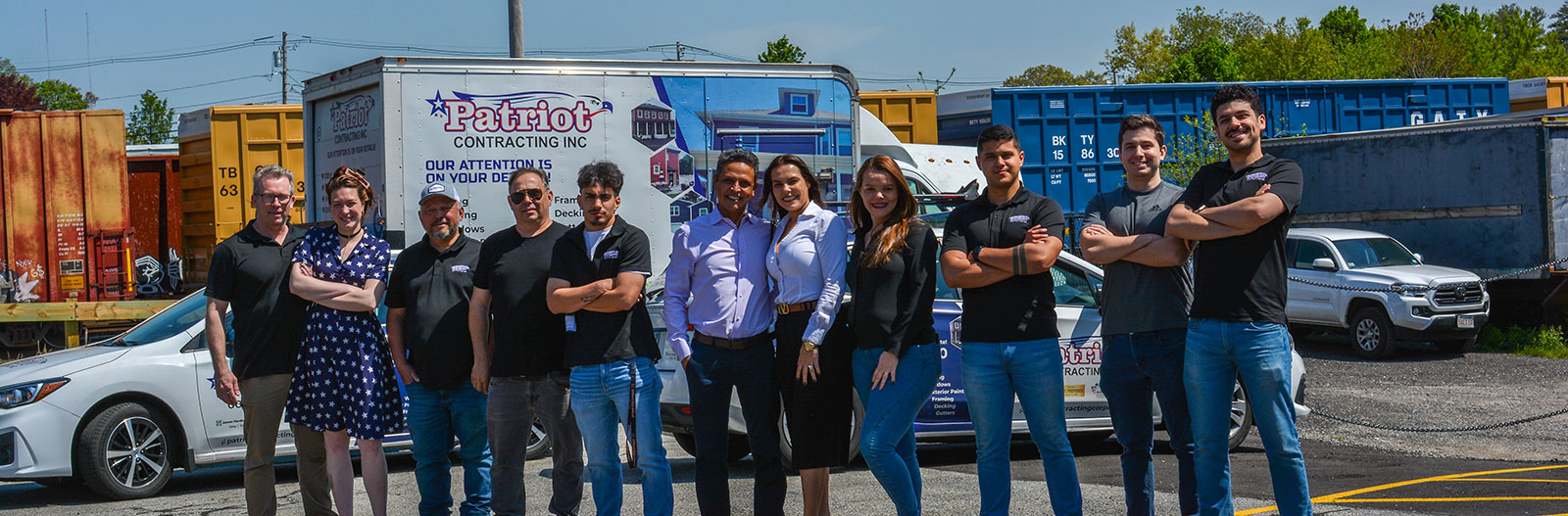 group_shot Group photo of Patriot Contracting staff standing in front of branded vehicles.